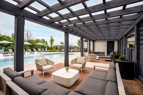 a patio with couches and chairs and a swimming pool